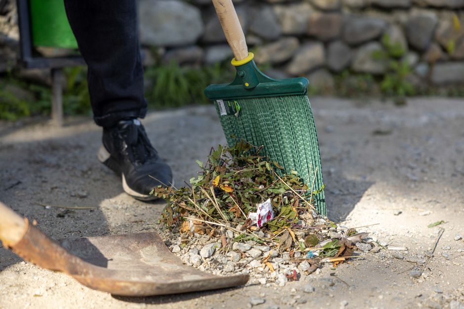 A close-up view of a garden bed filled with finely chopped wood mulch, showcasing a mixture of small, irregularly shaped pieces with rough textures and natural wood tones. The mulch covers the soil su
